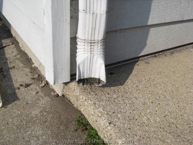 Rain gutter downspout maintenance - clogged downspout discharge end