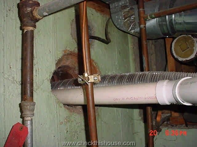 High efficiency PVC pipe and water heater vent pipe in the same chimney flue - not permitted