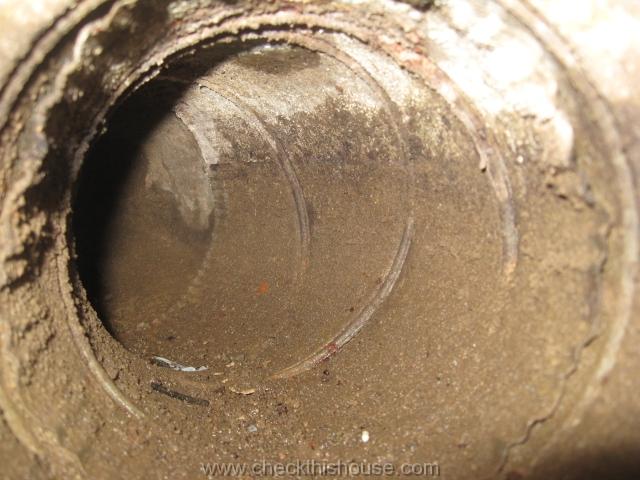 Musty odor from air ducts - wet and contaminated interior of the forced air heating system ducts installed under the house concrete floor