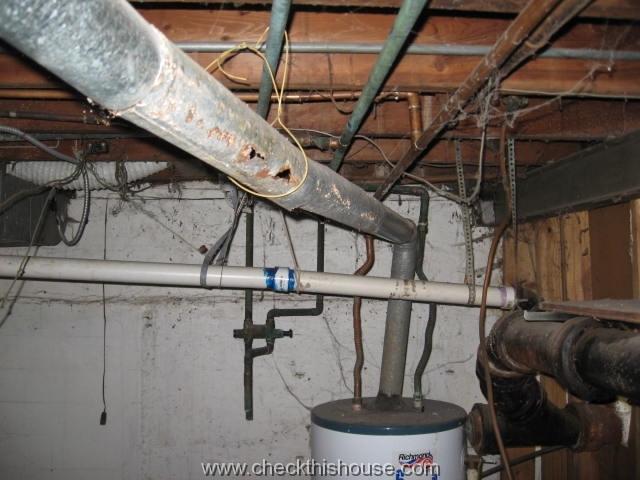Severely corroded water heater vent pipe poses safety hazard, possibility of Carbon Monoxide poisoning