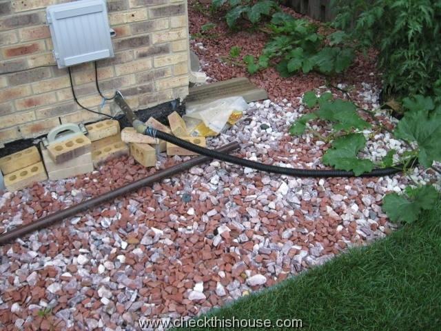 House sump pump flexible discharge pipe on exterior 